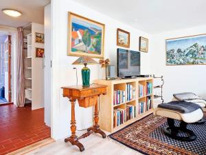 uma sala de estar com televisão e uma estante de livros com livros em Holiday home Rønne VI em Rønne