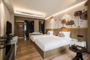 a hotel room with two beds and a television at Paco Hotel Shuiyin Road Guangzhou-Canton Fair free shuttle bus in Guangzhou