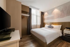 a hotel room with a bed and a tv at Paco Hotel Shuiyin Road Guangzhou-Canton Fair free shuttle bus in Guangzhou