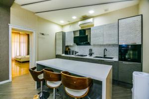 een keuken met een wit aanrecht en een aantal bruine stoelen bij CENTER. 3 Bedrooms in Baku