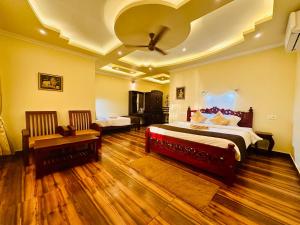 Maadathil Cottages & Beach Resort في فاركَالا: غرفة نوم كبيرة بسرير كبير وأرضيات خشبية
