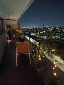 a chair sitting on top of a balcony at night at Habitación departamento Bilbao in Santiago