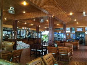 una sala da pranzo con tavoli e sedie in legno di Dreamland Resort a Thong Nai Pan Yai