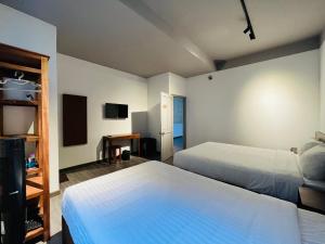 um quarto de hotel com duas camas e uma televisão em MAISON DU CIEL DALAT em Da Lat