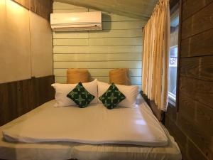 a bed with two pillows on it in a room at A-HOME in Jiufen