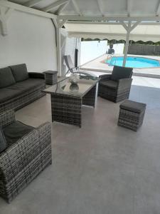 a patio with couches and a table and a pool at L'INSTANT PRESENT in Le Moule