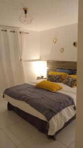 a bedroom with a large bed with yellow pillows at L'INSTANT PRESENT in Le Moule