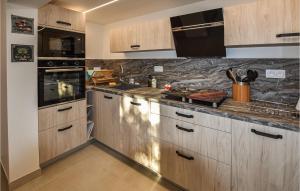 a kitchen with wooden cabinets and a counter top at Lovely Home In Villes-Sur-Auzon in Villes-sur-Auzon