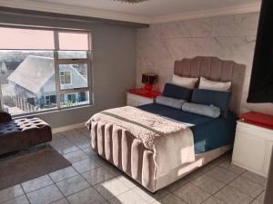 ein Schlafzimmer mit großem Bett und Fenster in der Unterkunft R & E Good vibes in Kapstadt