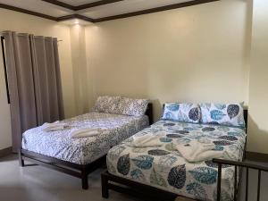 BatuanにあるZL TRAVELERS INNのベッド1台とソファが備わる小さな客室です。
