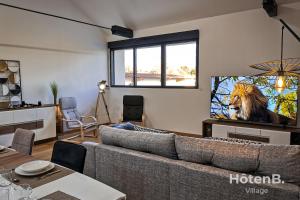 a living room with a couch and a tv at Spacious Cocoon with AC and PARKING At the Heart of Feytiat Limoges in Feytiat