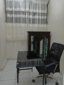 een glazen tafel en een stoel in een kamer met een raam bij Edificio Riviera in Guayaquil
