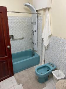 een badkamer met een blauw bad en een toilet bij Edificio Riviera in Guayaquil