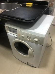 een wasmachine met een handtas erop bij شقة in Alexandrië