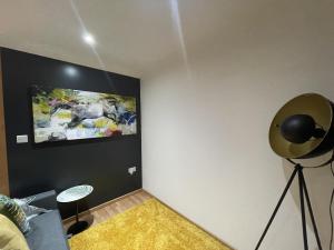 a room with a fan and a painting on the wall at Chic Citispace -1-Bed Apartment Leeds City-WiFi in Leeds