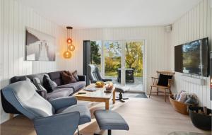 a living room with a couch and a table at Nice Home In Sams With Wi-fi in Nordby