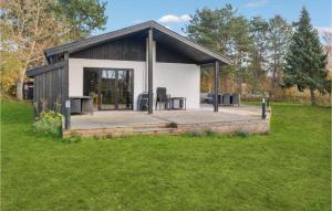 a small house with a wooden deck in a field at Nice Home In Sams With Wi-fi in Nordby