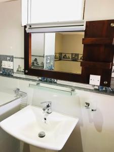 a bathroom with a white sink and a mirror at Ella HIDE VIEW in Ella