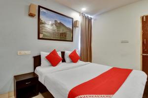 a bedroom with a bed with red pillows at OYO Flagship Hotel Shiva Shakthi Inn in Bangalore