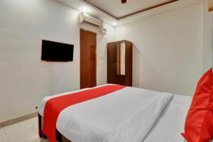 a bedroom with a bed and a tv on the wall at OYO Flagship Hotel Shiva Shakthi Inn in Bangalore