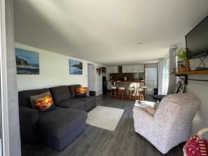 a living room with a couch and a kitchen at Awa Tui Batch in Blenheim