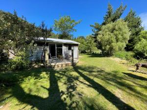 a small cabin in the middle of a yard at Awa Tui Batch in Blenheim