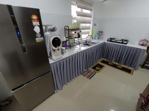 cocina con nevera de acero inoxidable y fregadero en JRC Homestay Kerteh, en Kampong Kemaman