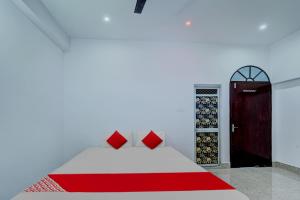 a bedroom with a red and white bed and a door at OYO Flagship Your Room & Guest House in Patna