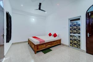a room with a bed with red pillows on it at OYO Flagship Your Room & Guest House in Patna