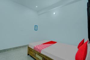1 dormitorio con 1 cama con almohadas rojas en OYO Flagship Your Room & Guest House en Patna