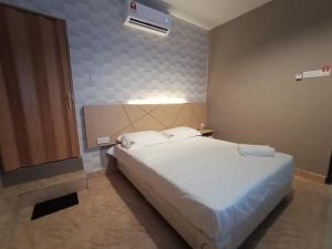 - une chambre avec un grand lit blanc dans l'établissement Dane & Shue Hotel Kok Lanas, à Kota Bharu