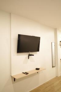 a flat screen tv hanging on a white wall at NOW’S HOSTEL in Ban Chang