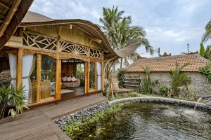 a house with a pond in front of a house at Arapan Ubud Eco Villa in Ubud