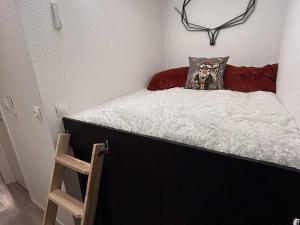 Dormitorio pequeño con cama blanca y negra con almohada en Studio Bolquère-Pyrénées 2000, 1 pièce, 4 personnes - FR-1-592-64, en Font-Romeu