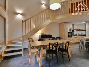 eine Küche und ein Esszimmer mit einem Holztisch und einer Treppe in der Unterkunft Maison Saint-Jean-de-Sixt, 5 pièces, 10 personnes - FR-1-391-179 in Saint-Jean-de-Sixt