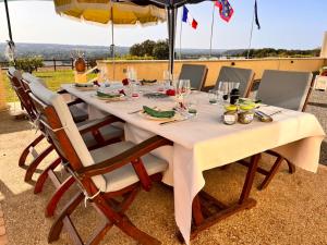 una mesa larga con sillas y sombrilla en Mon "Chateau" FRAUSSIE, en Chahaignes