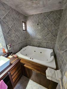 ein Bad mit einer Badewanne in einem Zimmer in der Unterkunft Chalet Fer Icho in Villa Icho Cruz
