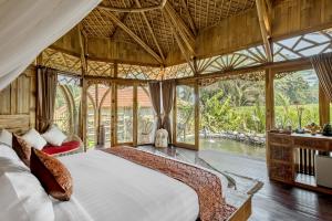 um quarto com uma cama num quarto com janelas em Arapan Ubud Eco Villa em Ubud