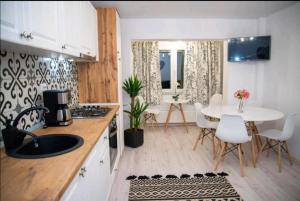 a kitchen and dining room with a table and chairs at Apartament Daria in Tîrgu Ocna