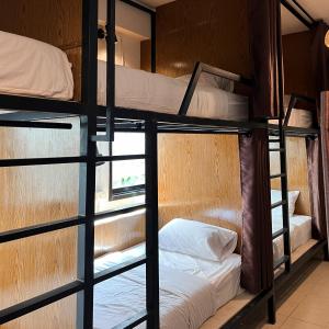 a room with four bunk beds with a window at Happiness Hostel in Phra Ae beach