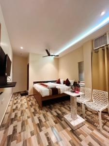 een slaapkamer met een bed en een tafel en stoelen bij RR PALACE in Gorakhpur