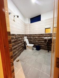 La salle de bains est pourvue de toilettes et d'un lavabo. dans l'établissement RR PALACE, à Gorakhpur