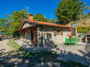 a small stone house with green chairs in front of it at BeB Il Poderino Family Room in Dicomano