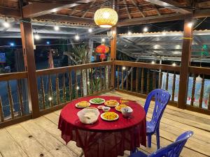 una mesa roja con comida en la parte superior de un balcón en Hồng Gấm Homestay, en Bak Kan