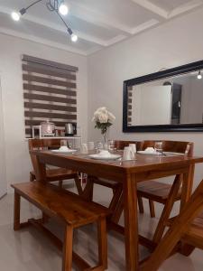 a dining room with a table and chairs and a mirror at The Doll House 2.0 in Abucay