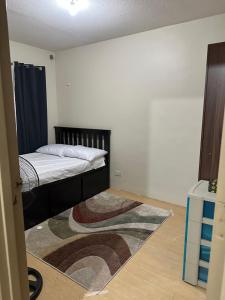 a bedroom with a bed and a rug on the floor at Sorrento Oasis 2 BR in Manila