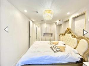 sypialnia z dużym białym łóżkiem ze złotą ramą w obiekcie Reimi Mondo201 w Tokio