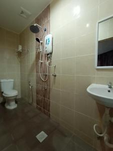 a bathroom with a shower and a toilet and a sink at Dane & Shue Hotel Kok Lanas in Kota Bharu