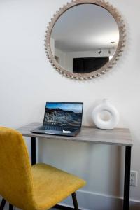 a laptop sitting on a table with a mirror at Chic 1-BR Condo; Parking included; Downtown Core in Toronto +49 photos