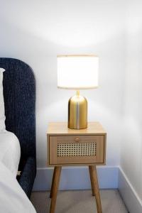 a lamp on a night stand next to a bed at Chic 1-BR Condo; Parking included; Downtown Core in Toronto